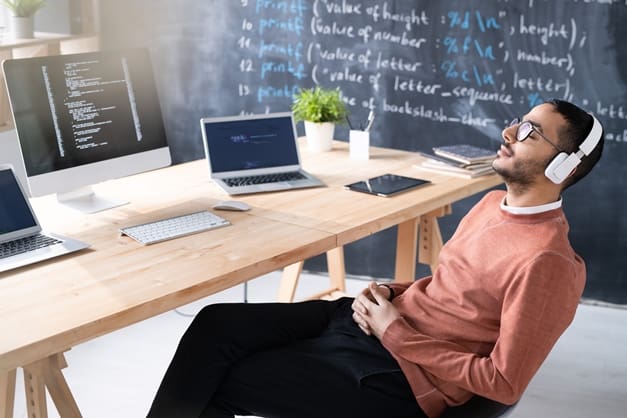 coder in headphones taking break at workplace SYX4R5G